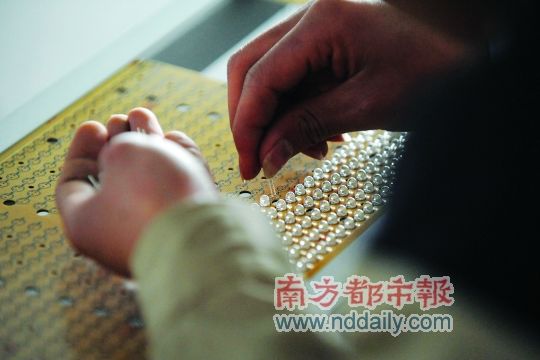 工人忙著安裝用于燈具發(fā)光的LED燈珠，這類工作處于LED燈具生產(chǎn)的最下游。資料圖